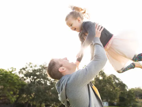 Daughter flying with Father outdoors
