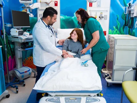 Doctor and nurse standing beside patient