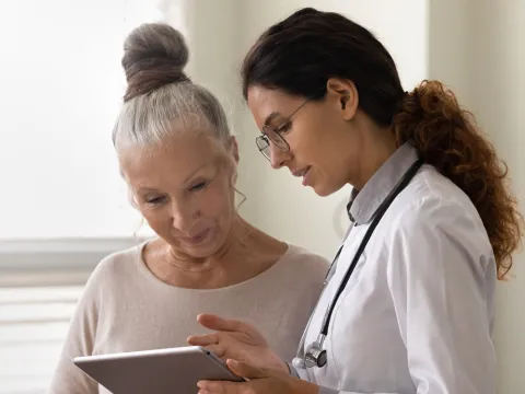 Doctor explaining to an older woman patient her test results.