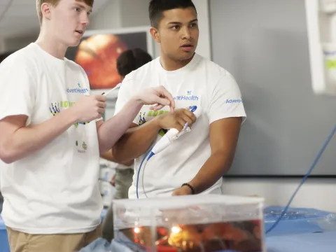 Two young men learning about robotic surgery