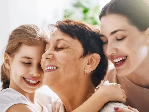 A girl, a young woman, and an older woman hugging.