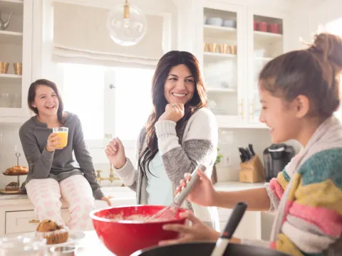 Mother baking with her daughters in the kitchen.