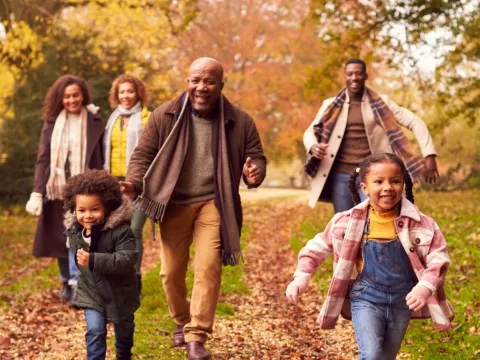 A family walking together outdoors in the fall.