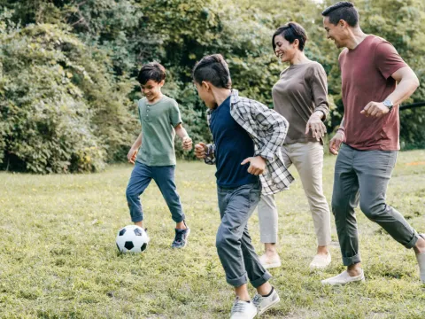 Family playing soccer together at home.