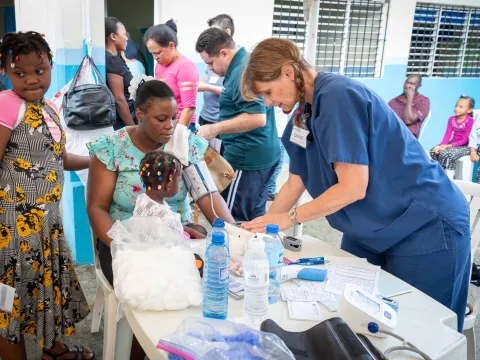 A nurse doing clinical work on a mother