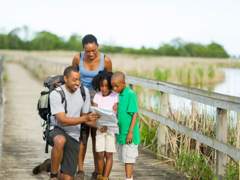 A family walking on a boardwalk together.