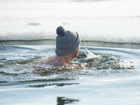 A man taking a swim in cold water.