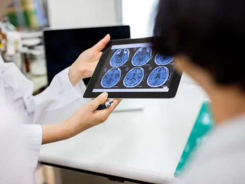 A hospital care team reviews scans of a patient's brain
