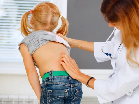 A child getting her spine examined.