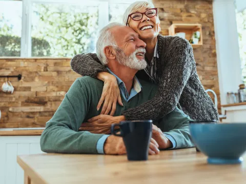 A couple hugging in the kitchen.