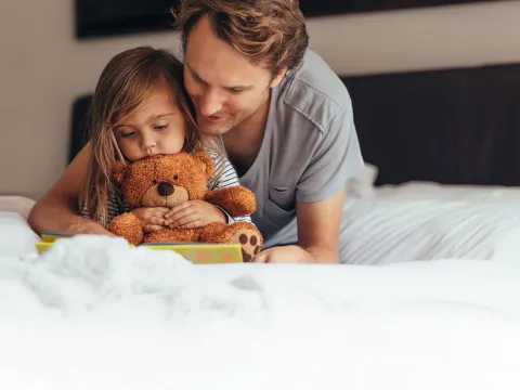 A dad and daughter reading together