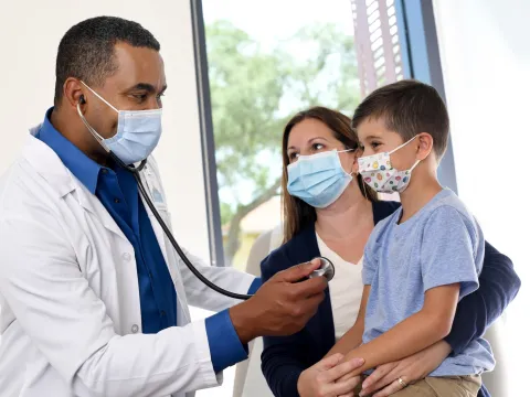A doctor treating a mother and son.
