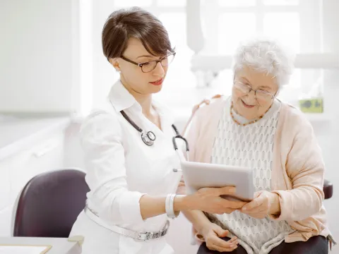 An elderly woman talks to her doctor