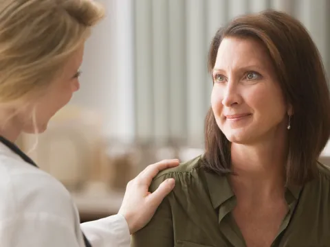 A doctor giving her patient words of strength as they talk
