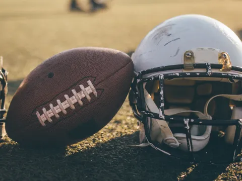 A helmet and a football on a field.