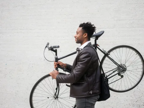 A man carries his bike after riding to work