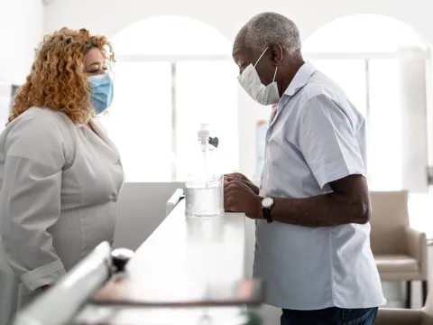 A man wearing a mask checking in for an appointment.