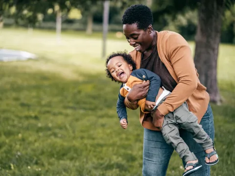 A mom and child playing outside.
