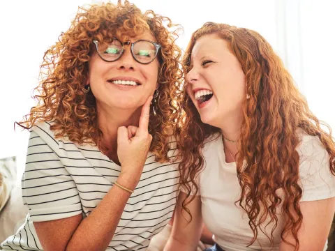 A mother and daughter joking and laughing together.