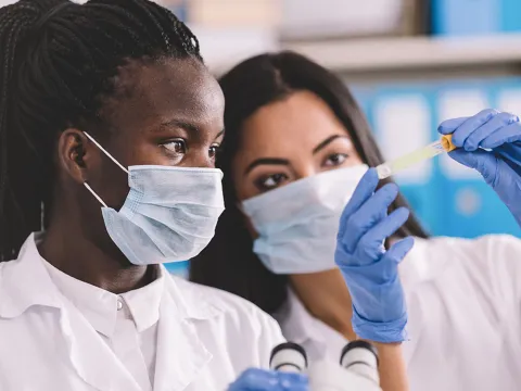 Two scientist looking at a vile in the lab