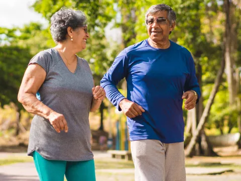 A mature couple exercising outdoors together.