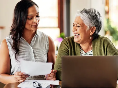 Two women doing research at the dining room table.