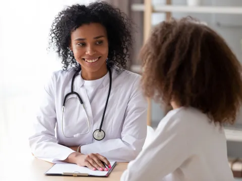 A black female doctor talks to an adult woman patient