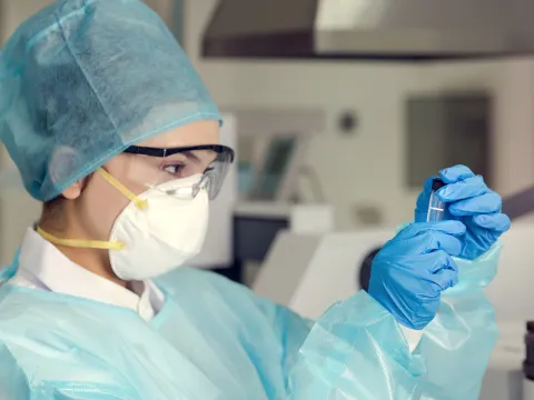 A woman analyzing a test sample.