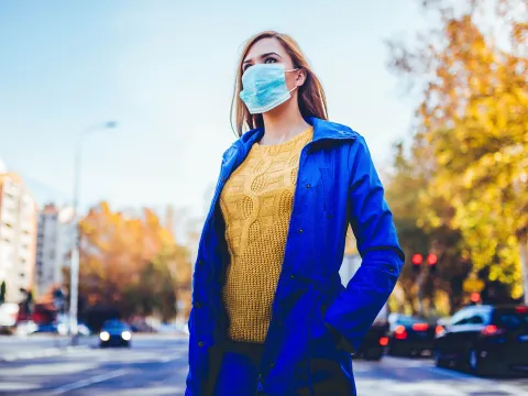 A woman wearing a mask outside.
