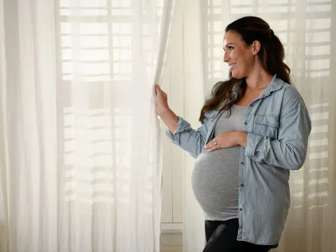 Pregnant woman standing near window