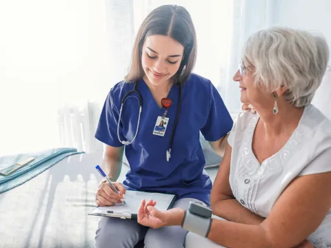 Nurse checking patients blood pressure.