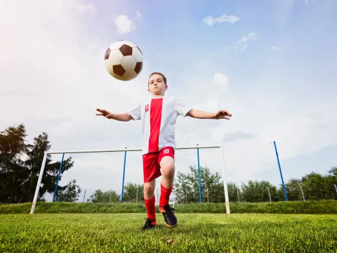 A young boy about to kick a soccer ball.