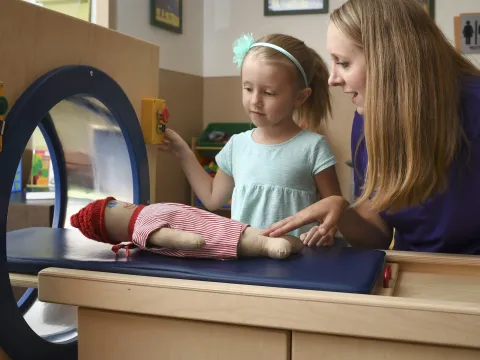 An imaging technician shows a child what to expect during an MRI.