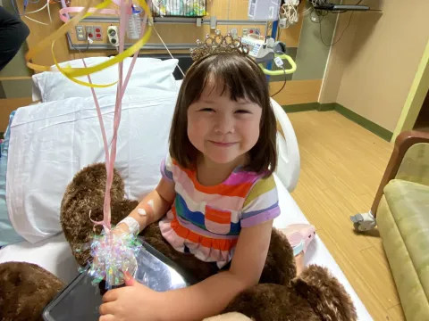 Faith Ahn smiles at the camera with balloons to celebrate leaving the hospital.