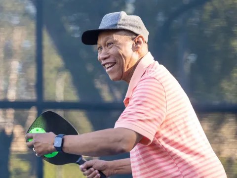 An older man playing Pickleball