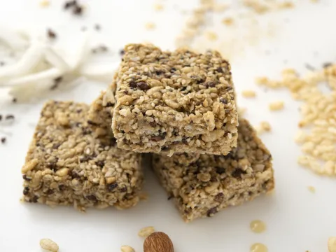 Stack of three crispy sesame treats on white surface