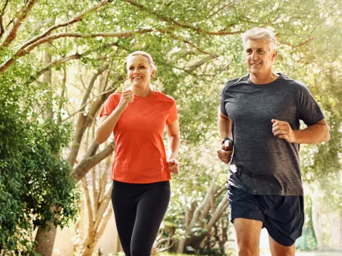 A Middle Aged Couple Jogging Through the Woods to Keep Fit