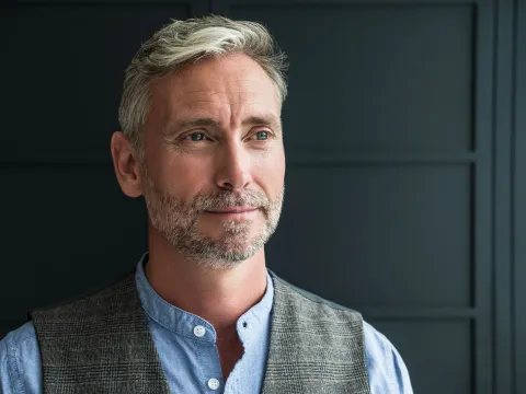 An older man in a vest.