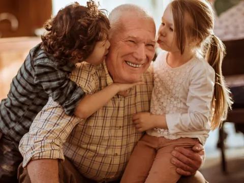 Children greeting Grandpa with a group hug.