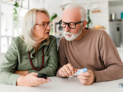 Older couple checking blood sugar