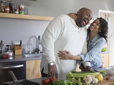 A mature couple enjoying their time while cooking.