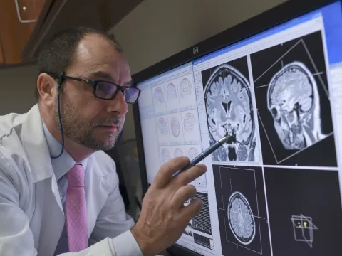 A physician reviewing MEG images on a computer monitor