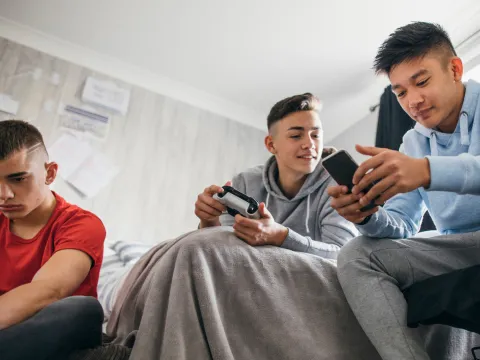 A group of teenage boys playing videogames.