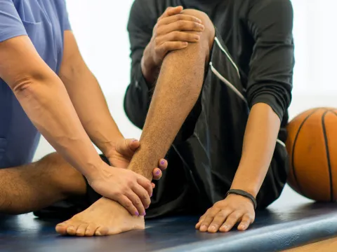 Sports medicine doctor examining a patient's ankle