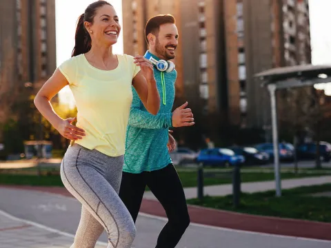 Couple running outside in the city during sunset.
