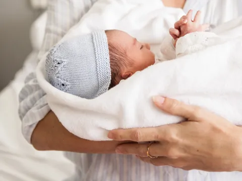 baby in adult's arms