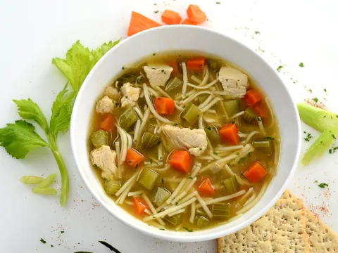 Bowl filled with a chicken noodle and vegetable soup