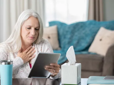 A senior woman talking to her doctor, virtually.