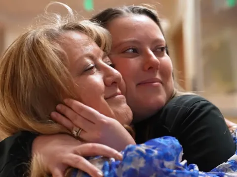 Liver transplant Shelly Kalahar receives a hug.