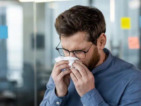 A man blowing his nose.